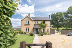 Front view of Conker Tree farmhouse with a stone driveway, set in green fields.