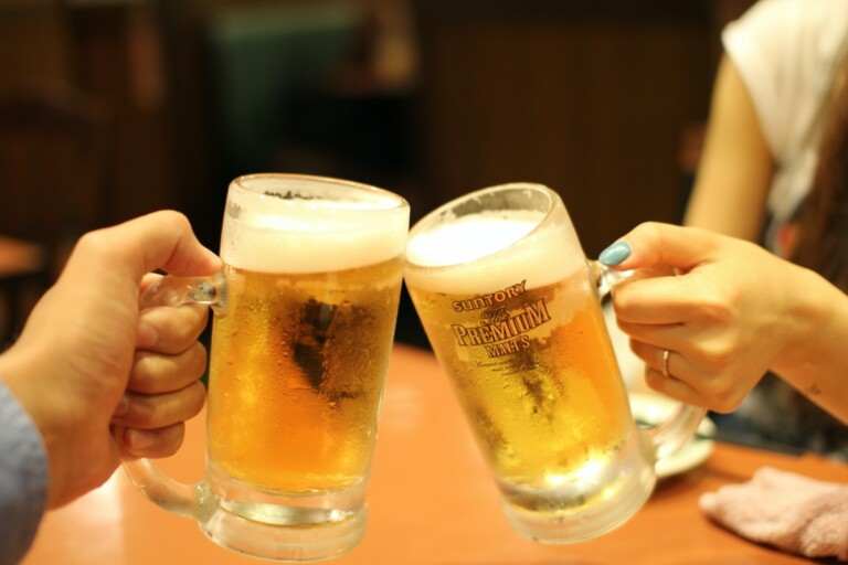 Two pints of beer clinking together.